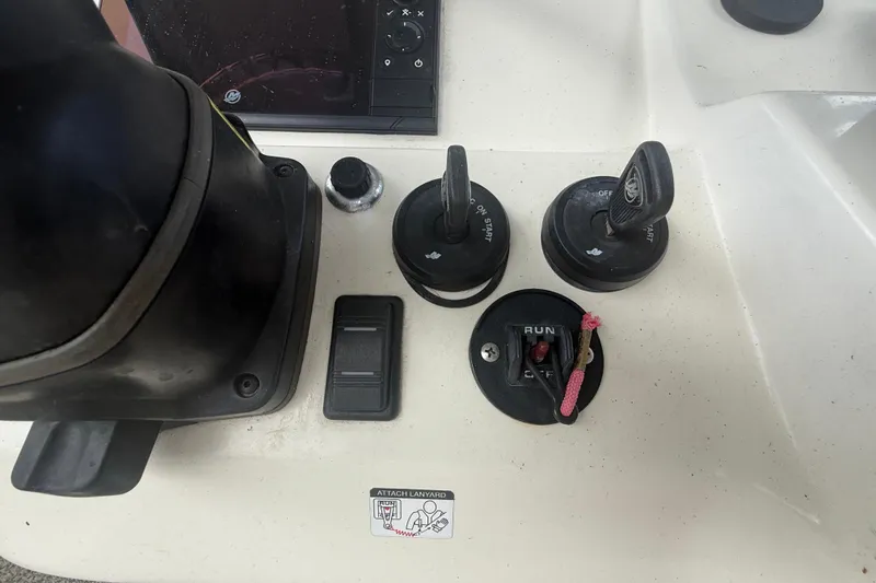 Slide: The Image of Control panel of a 2022 Eastward 30 boat with ignition switches and safety lanyard. - 61
