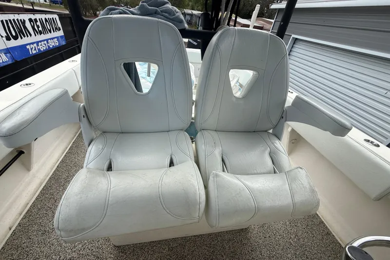 Slide: The Image of Two white cushioned boat seats on a 2022 Eastward 30 model. - 63