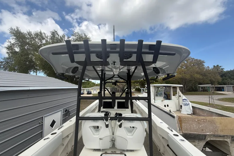 Slide: The Image of 2022 Eastward 30 boat with T-top, docked outdoors under a cloudy sky. - 70