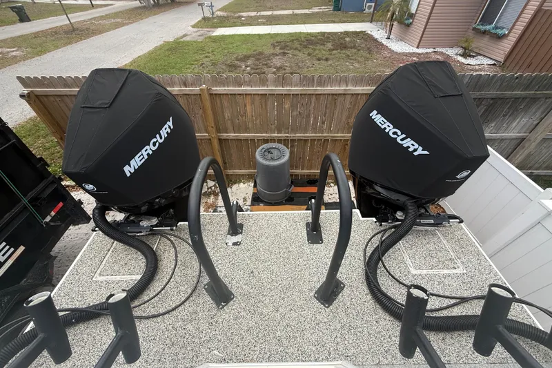 Slide: The Image of Twin Mercury outboard motors on a 2022 Eastward 30 boat, parked in a residential area. - 77