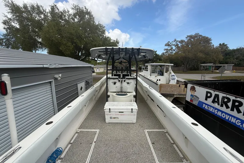 Slide: The Image of 2022 Eastward 30 boat with center console and storage, docked near trees and buildings. - 82