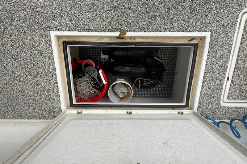 Slide: The Image of Open storage compartment on 2022 Eastward 30 boat with fishing gear and equipment. - 85