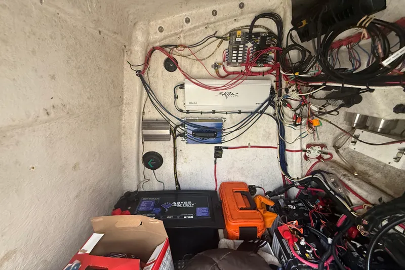 Slide: The Image of Electrical wiring and components inside a 2022 Eastward 30 boat, featuring batteries and equipment. - 98