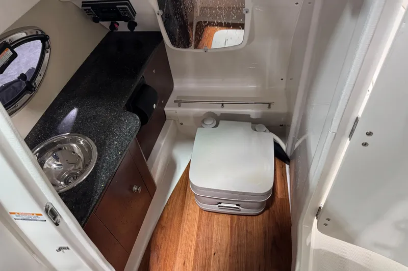 Slide: The Image of 2014 Chaparral 287 SSX boat interior with sink, countertop, and portable toilet. - 14
