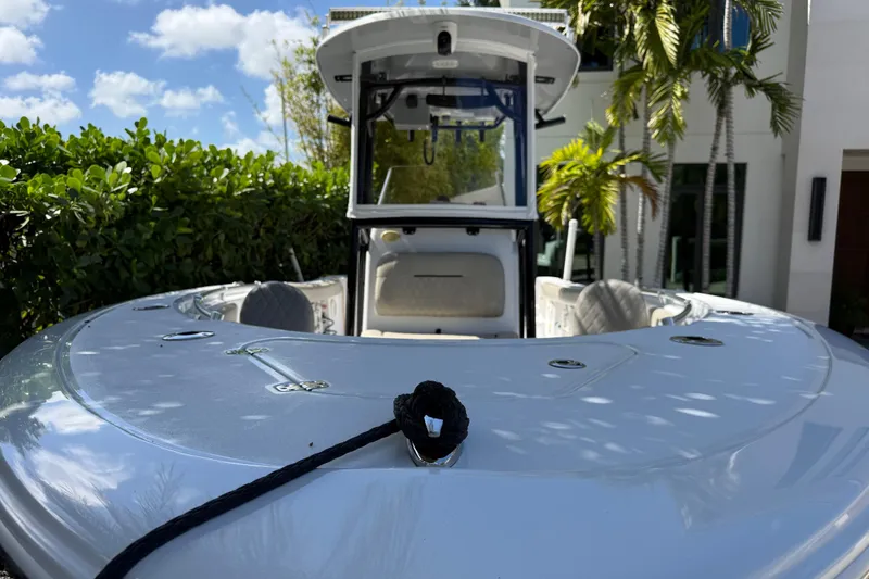 Slide: The Image of 2021 P Open 232 Center Console boat docked near tropical foliage and modern house. - 1