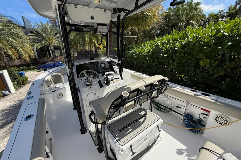Slide: The Image of 2021 P Open 232 Center Console boat with modern dashboard and seating, surrounded by lush greenery. - 12