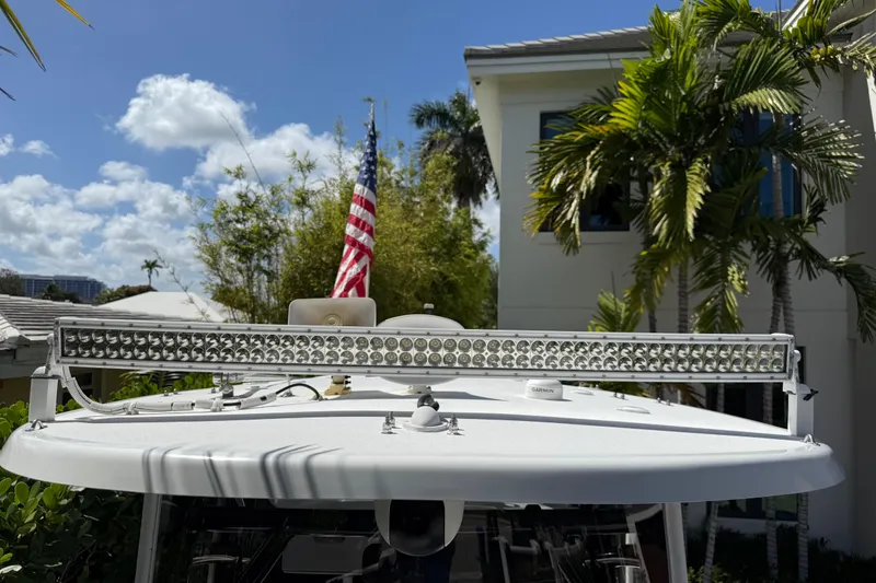 Slide: The Image of 2021 P Open 232 Center Console boat with light bar, American flag, and tropical background. - 18