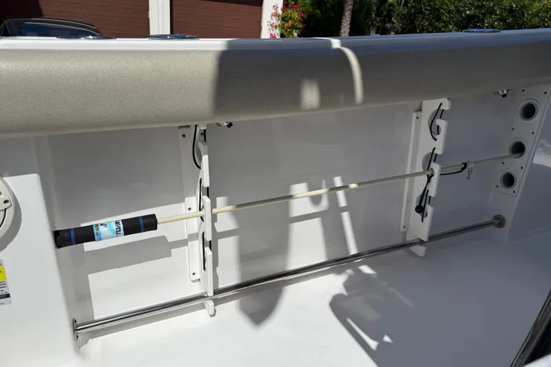 Slide: The Image of 2021 P Open 232 Center Console boat interior with rod holders and cushioned seating. - 23