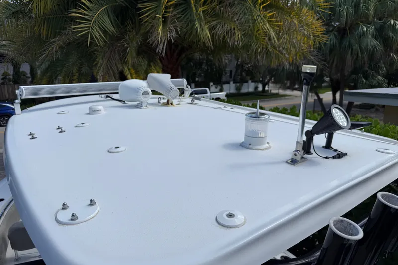 Slide: The Image of 2021 P Open 232 Center Console boat roof with mounted equipment and palm trees in background. - 24