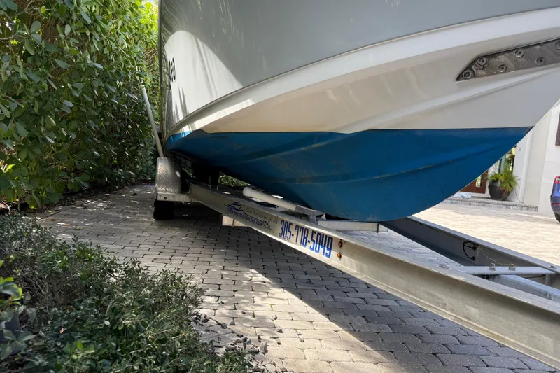 Slide: The Image of 2021 P Open 232 Center Console boat on trailer, parked on paved driveway. - 28