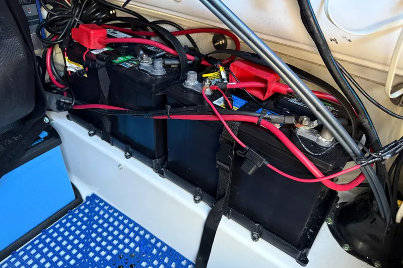 Slide: The Image of Battery setup in a 2021 P Open 232 Center Console boat, featuring red and black cables. - 30