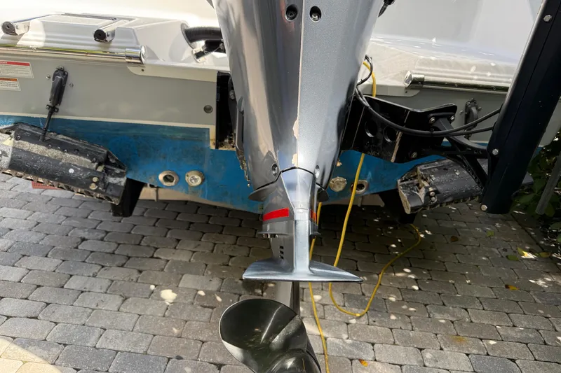 Slide: The Image of 2021 P Open 232 Center Console boat engine and propeller on paved surface. - 6