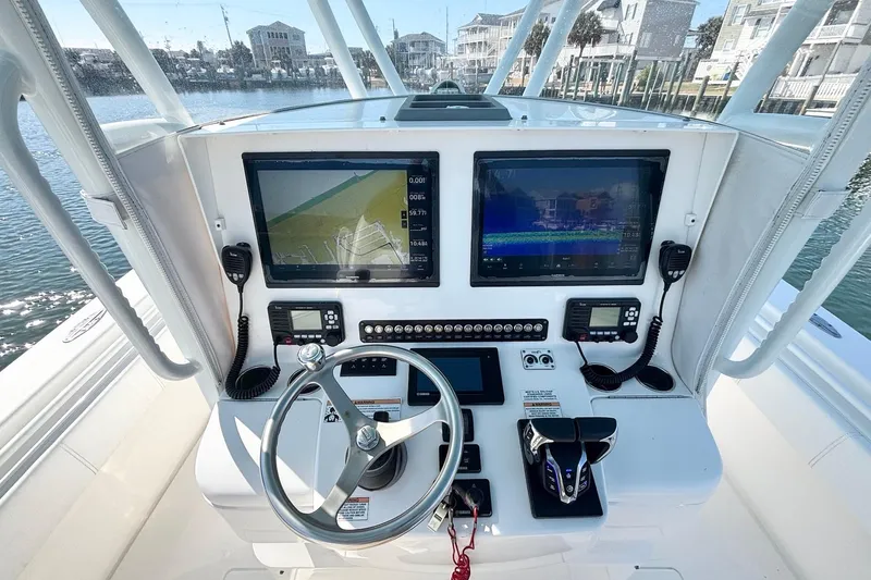 Slide: The Image of 2020 Contender 35 ST boat dashboard with dual screens and controls. - 10