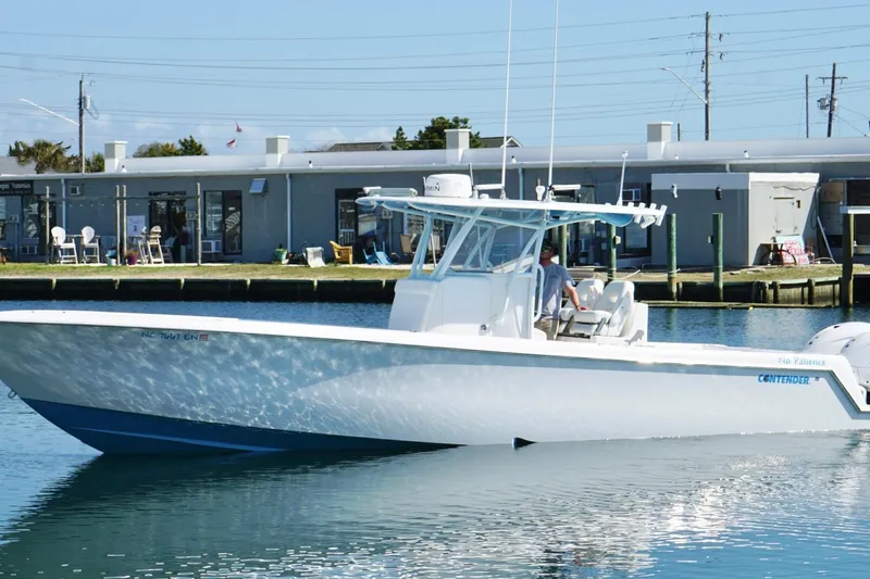 Slide: The Image of 2020 Contender 35 ST boat on calm water near a dockside building. - 13