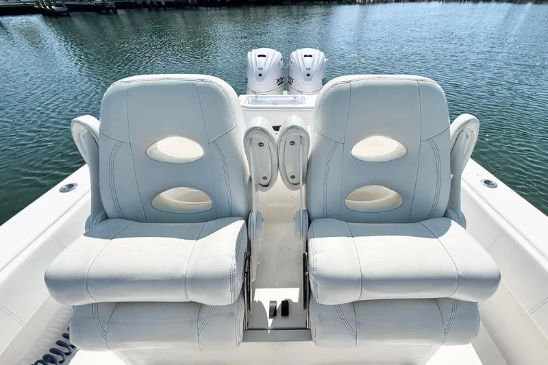 Slide: The Image of 2020 Contender 35 ST boat with dual white cushioned seats on a calm water backdrop. - 16