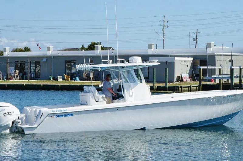 Slide: The Image of 2020 Contender 35 ST boat on water near dock, featuring sleek design and powerful engines. - 6