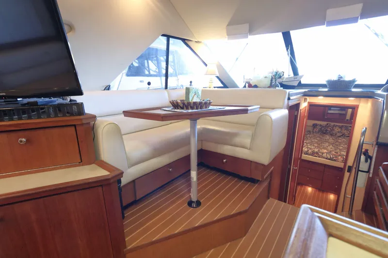 Slide: The Image of Interior of 1995 Bayliner 3988 Command Bridge Motoryacht with cozy seating and wooden finishes. - 11