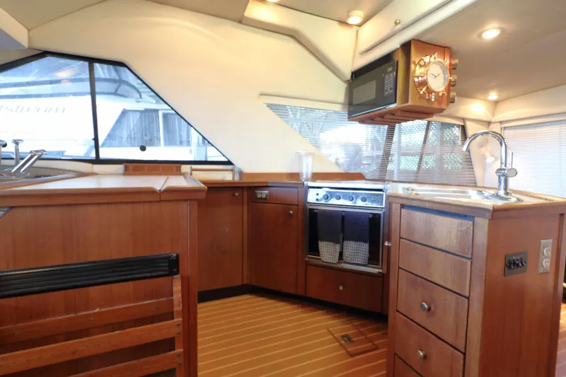 Slide: The Image of Interior of 1995 Bayliner 3988 Command Bridge Motoryacht with wooden cabinetry and modern amenities. - 15