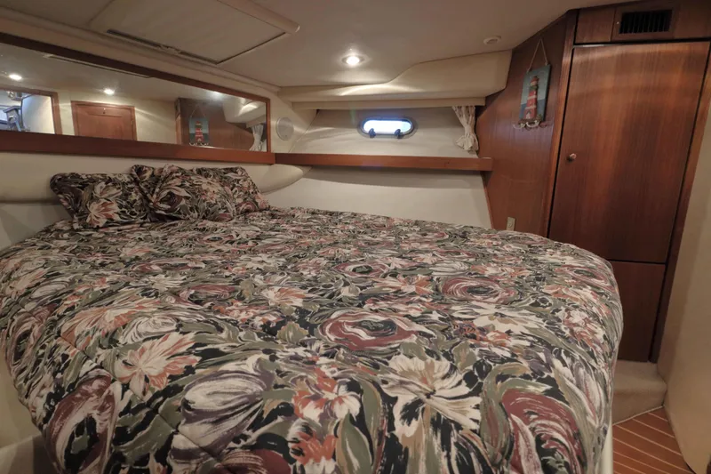 Slide: The Image of Cozy bedroom in 1995 Bayliner 3988 Command Bridge Motoryacht with floral bedding and wood accents. - 17