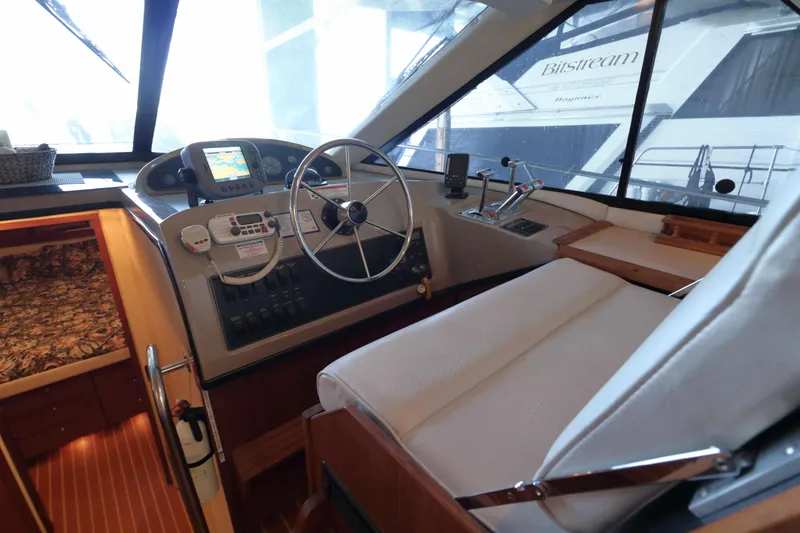 Slide: The Image of 1995 Bayliner 3988 Command Bridge Motoryacht helm with steering wheel and navigation equipment. - 7