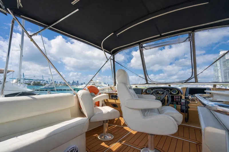 Slide: The Image of Interior view of 2004 Carver 420 Mariner yacht with luxurious seating and city skyline. - 12