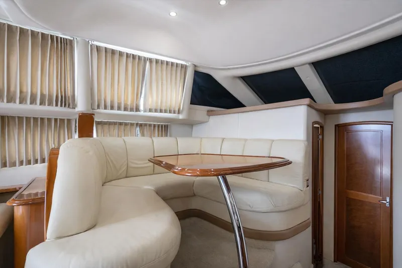 Slide: The Image of Interior of 2004 Carver 420 Mariner yacht with plush seating and wooden table. - 16