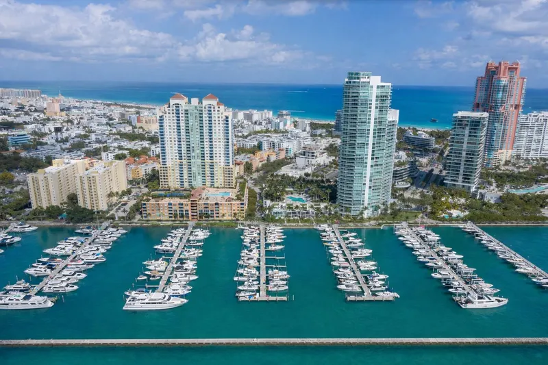 Slide: The Image of Aerial view of a marina with yachts, cityscape, and ocean backdrop. - 21