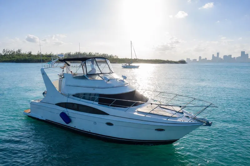 Slide: The Image of 2004 Carver 420 Mariner yacht on serene blue waters with city skyline in background. - 3