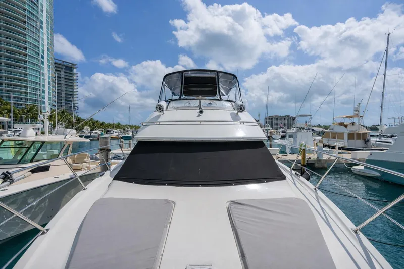 Slide: The Image of 2004 Carver 420 Mariner yacht docked at marina, surrounded by other boats and high-rise buildings. - 7
