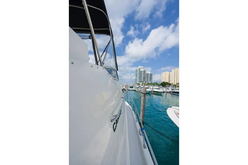 Slide: The Image of 2004 Carver 420 Mariner yacht docked in a marina with city skyline. - 9