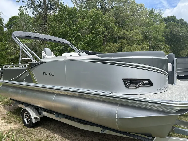 The Image of 2026 Tahoe Pontoon LTZ 23 Entertainer boat on trailer outdoors. - 1