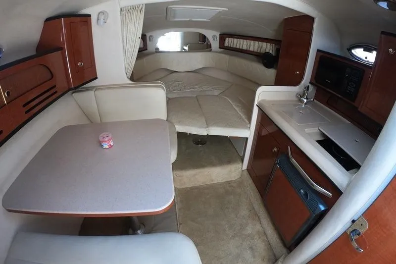 Slide: The Image of 2004 Sea Ray Sundancer 280 cabin interior with kitchenette and seating area. - 11