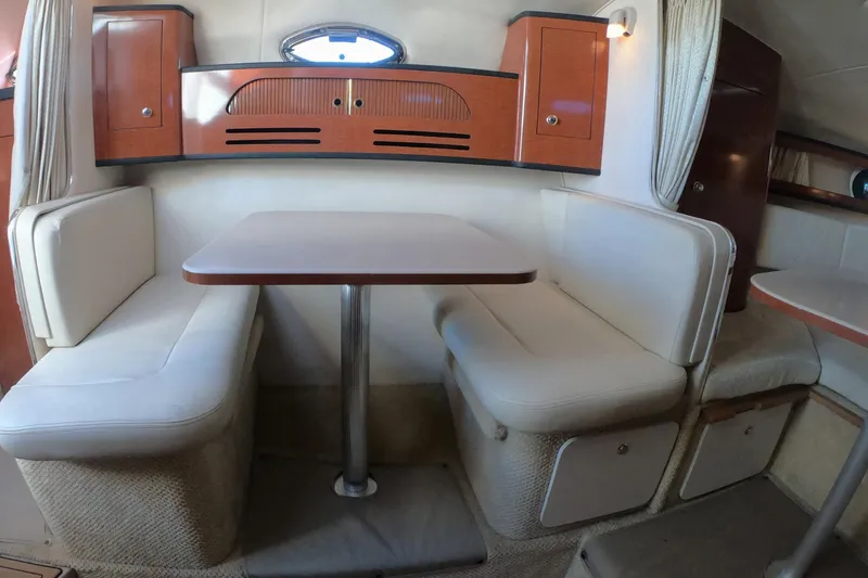 Slide: The Image of 2004 Sea Ray Sundancer 280 interior with cozy dining area and wooden cabinetry. - 17