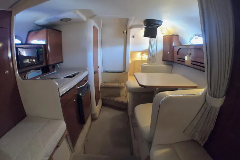 Slide: The Image of 2004 Sea Ray Sundancer 280 interior with kitchenette, dining area, and cozy seating. - 18