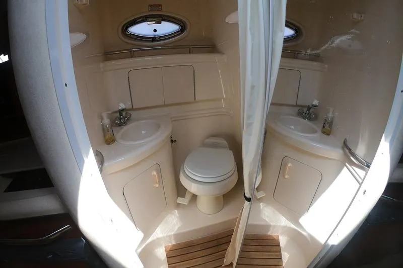 Slide: The Image of 2004 Sea Ray Sundancer 280 bathroom with sink, toilet, and porthole window. - 19