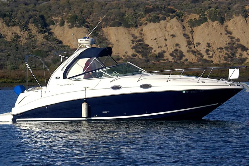 Slide: The Image of 2004 Sea Ray Sundancer 280 cruising on a calm lake with scenic hillside backdrop. - 2