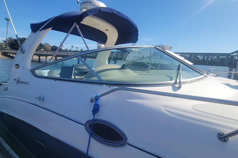 Slide: The Image of 2004 Sea Ray Sundancer 280 docked, featuring sleek design and blue canopy. - 20