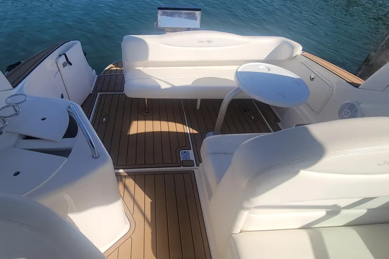 Slide: The Image of 2004 Sea Ray Sundancer 280 interior with white seating and wooden deck. - 27