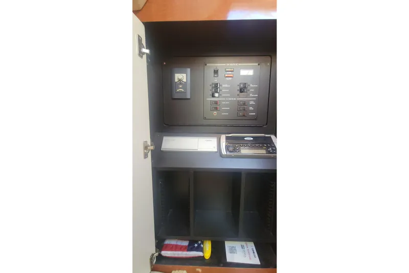 Slide: The Image of 2004 Sea Ray Sundancer 280 electrical panel with control switches and storage compartments. - 29