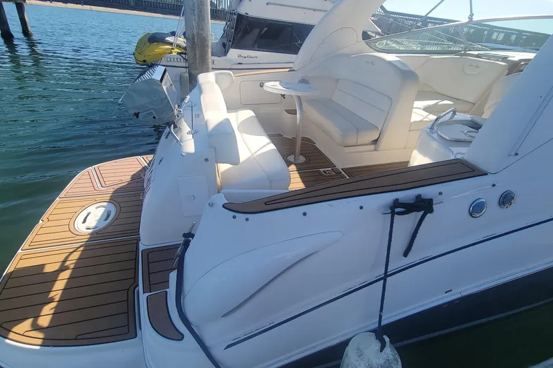 Slide: The Image of 2004 Sea Ray Sundancer 280 with spacious deck and seating, docked by the water. - 4
