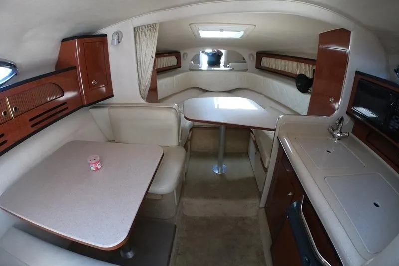 Slide: The Image of 2004 Sea Ray Sundancer 280 cabin interior with dining area and kitchenette. - 9