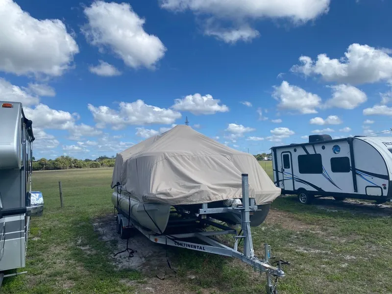 Slide: The Image of 2019 Bennington 198SL boat with cover on trailer outdoors. - 12