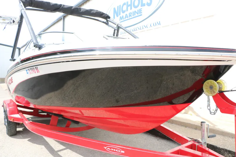 Slide: The Image of 2010 Tahoe Q7i boat on red trailer at Nichols Marine dealership. - 12