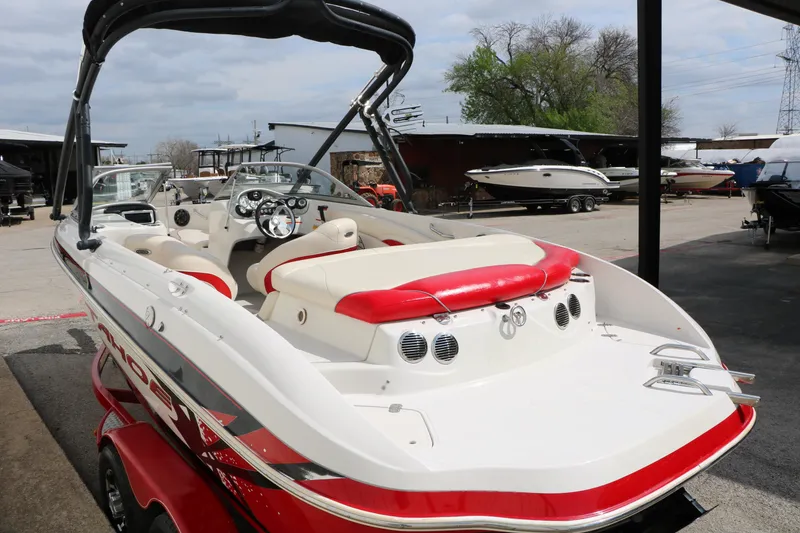 Slide: The Image of 2010 Tahoe Q7i boat with red and white interior, parked in a marina. - 14