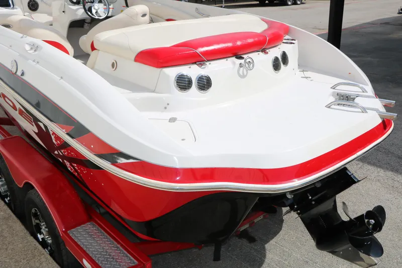 Slide: The Image of 2010 Tahoe Q7i boat with red and white design, rear view on trailer. - 15