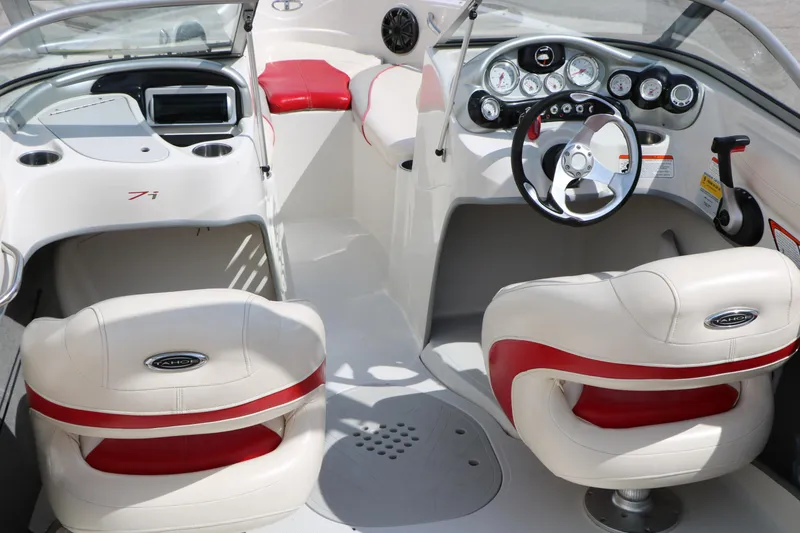 Slide: The Image of 2010 Tahoe Q7i boat interior with red and white seating, steering wheel, and dashboard controls. - 18