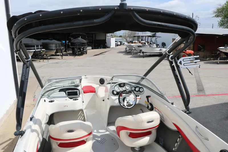 Slide: The Image of 2010 Tahoe Q7i boat interior with steering wheel and seating, parked in a marina. - 20