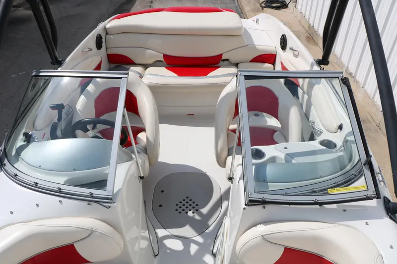 Slide: The Image of 2010 Tahoe Q7i boat interior with red and white seating, steering wheel, and cup holders. - 24