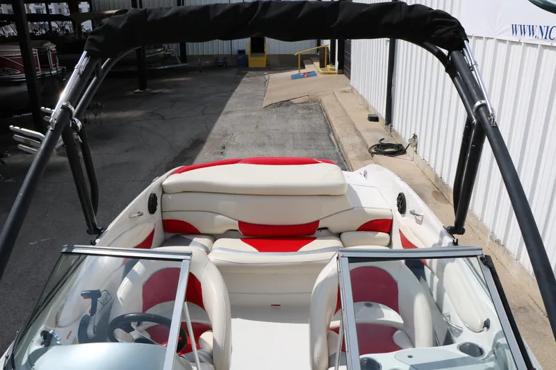 Slide: The Image of 2010 Tahoe Q7i boat interior with red and white seating, docked in a marina. - 25