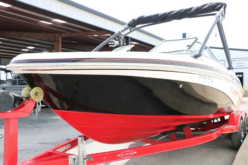Slide: The Image of 2010 Tahoe Q7i boat on red trailer in marina setting. - 6